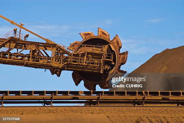 iron ore mine site with reclaimer running  - mining western australia stock pictures, royalty-free photos & images