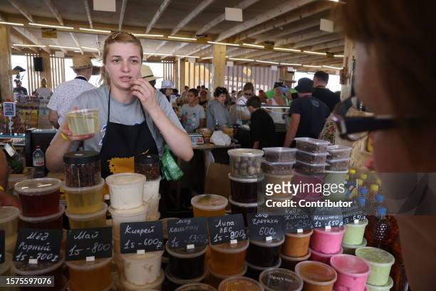 Visitors choose honey while visiting the "Cheese. Feast. World" festival on August 4, 2023 in Istra, 56 km west of Moscow, Russia. 350 food companies...