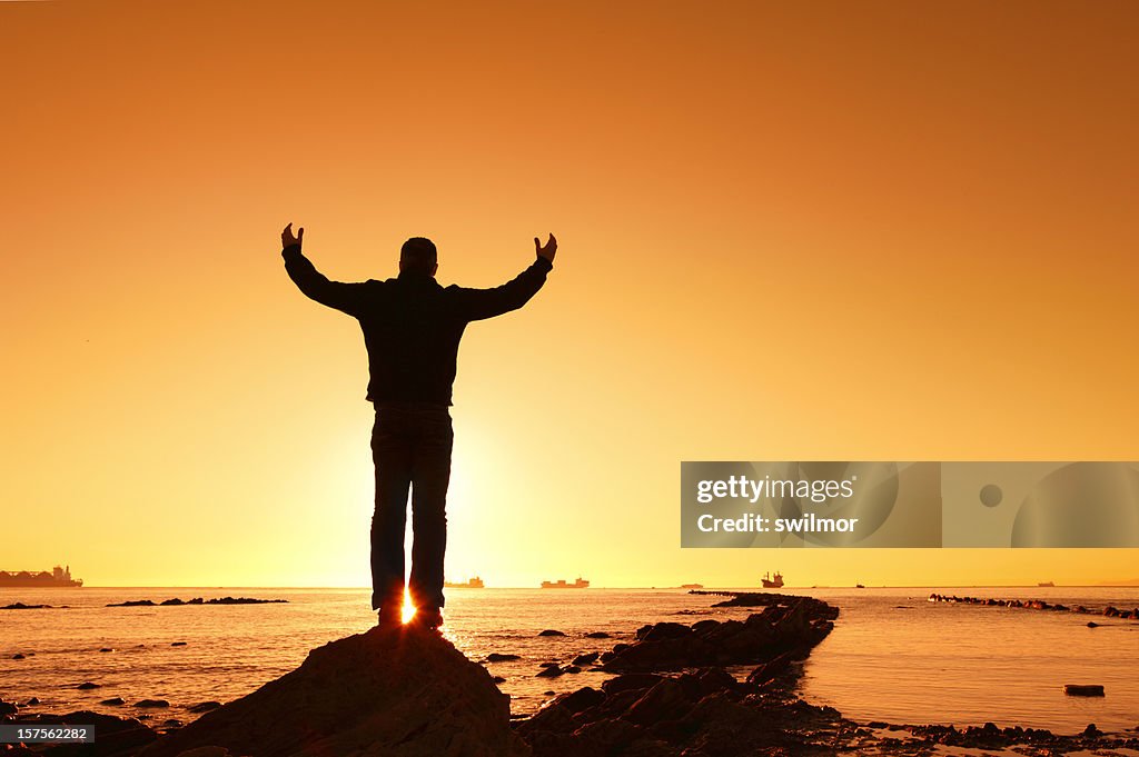 Man Lifting Hands at Sunrise