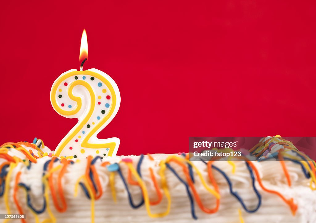 Decorated cake  with number 2 burning candles