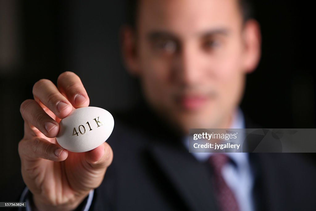 Young business man holding egg