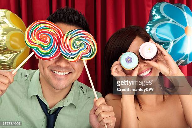 cute couple with lollipop and cupcakes - lolly models stockfoto's en -beelden