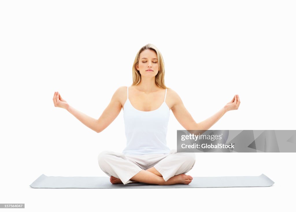 Young lady meditating in lotus position over white