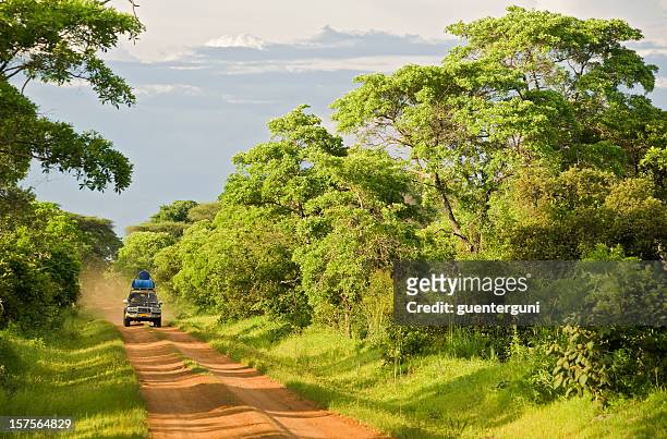 geländewagen auto auf einem nicht asphaltierte straße in ländlichen afrika - burundi ostafrika stock-fotos und bilder