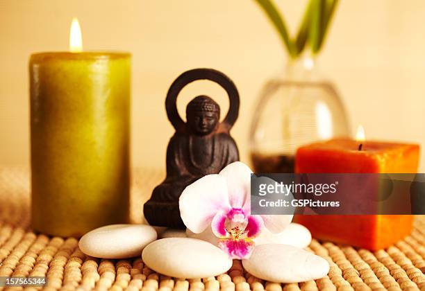 spa still life buddha statue and candles, orchid flower - feng shui house stock pictures, royalty-free photos & images