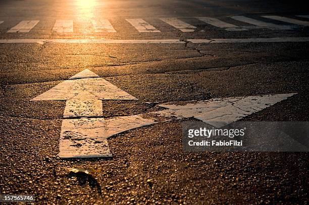 arrow on road - road intersection stock pictures, royalty-free photos & images