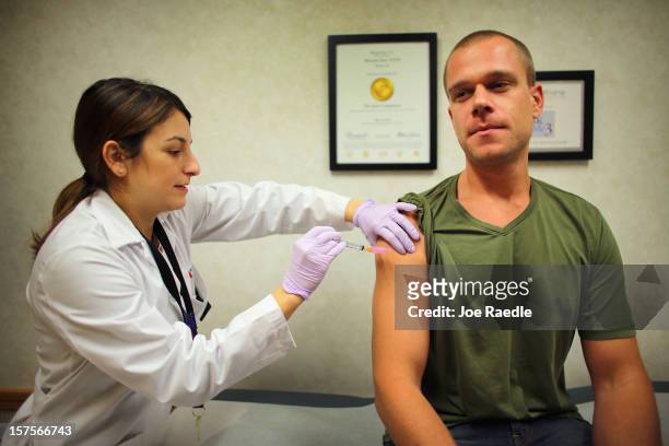 Alina Pastoriza Garcia, ARNP-NP-C, administers a flu vaccination to Russell Waddey at the CVS/pharmacy's MinuteClinic on December 4, 2012 in Miami,...