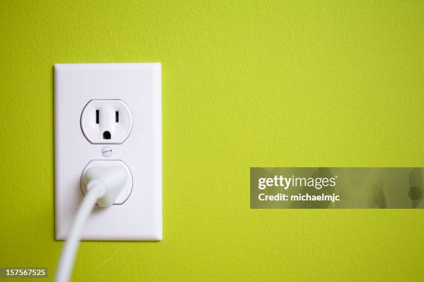 a green wall with a power socket - power point stock pictures, royalty-free photos & images