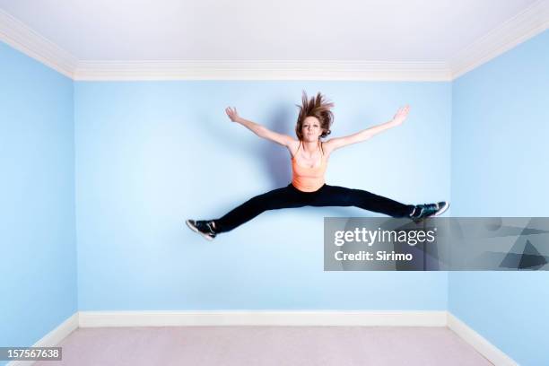 star jump in blue room - jumping jack stock pictures, royalty-free photos & images