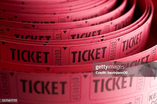 close up of roll of pink ticket stubs - ticket stockfoto's en -beelden