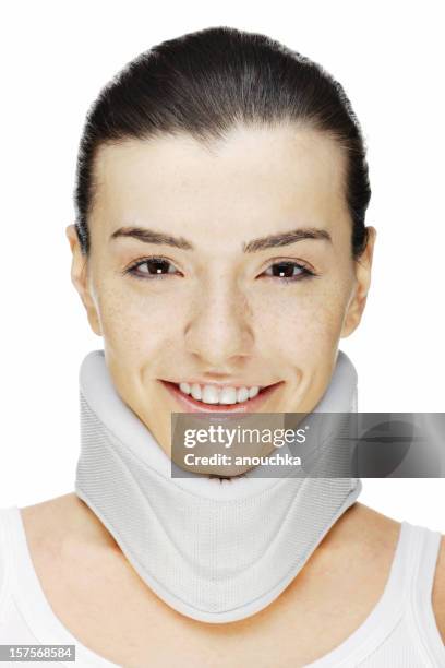 hermosa mujer joven en corsé de cuello sonriendo sobre fondo blanco - collarín médico fotografías e imágenes de stock