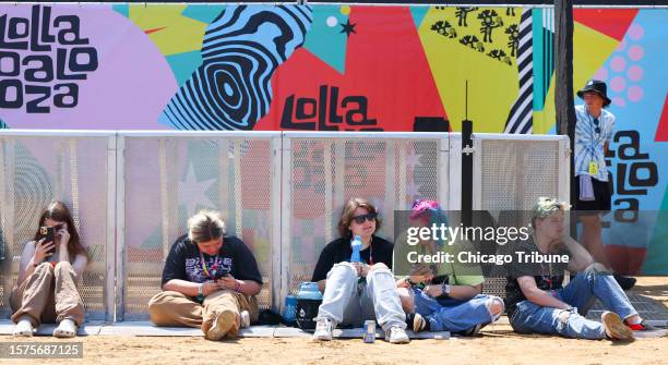 August Gibson, second from left, Jillian Mohr, RJ Kinzie, and Vincent Gibson sit near the front of the T-Mobile Stage to wait for the headliner,...