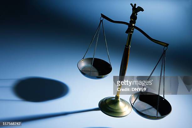 lone justice scale on simple blue background - gerechtigheid stockfoto's en -beelden
