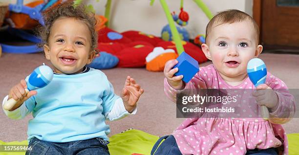 babies enjoying music through play - baby rattle stock pictures, royalty-free photos & images