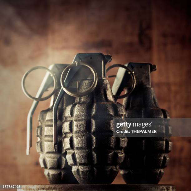 hand granades inmitten von rauch - handgranate stock-fotos und bilder
