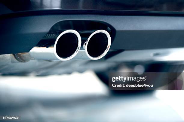 stainless steel exhaust pipes on a blue car - volkswagen ag automobiles stockpiled ahead of emissions testing stockfoto's en -beelden