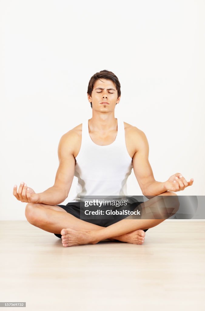 Young spiritual man meditating in a alotus position