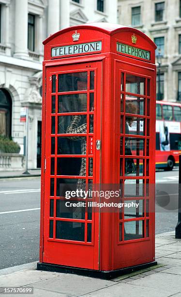 london telefonzelle mit frau mit telefon - telefonzelle stock-fotos und bilder