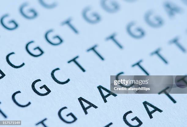 macro of blue-tinted dna nucleotide sequence printout on paper - sequencing stock pictures, royalty-free photos & images