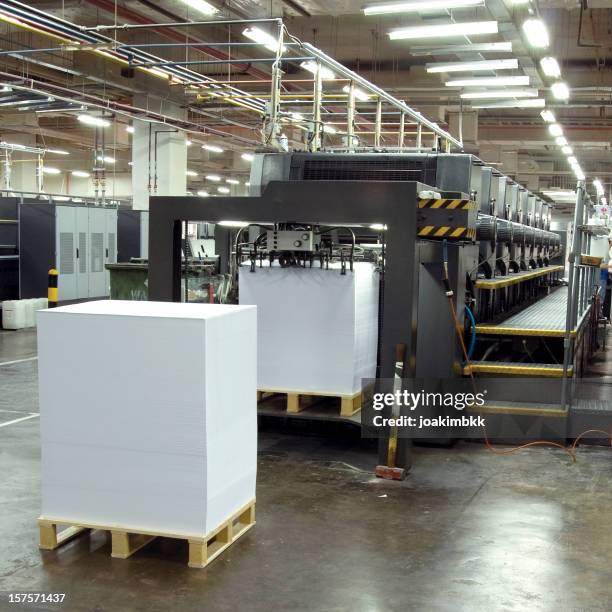 printing press with pile of papers in a printing factory - book printing press stock pictures, royalty-free photos & images