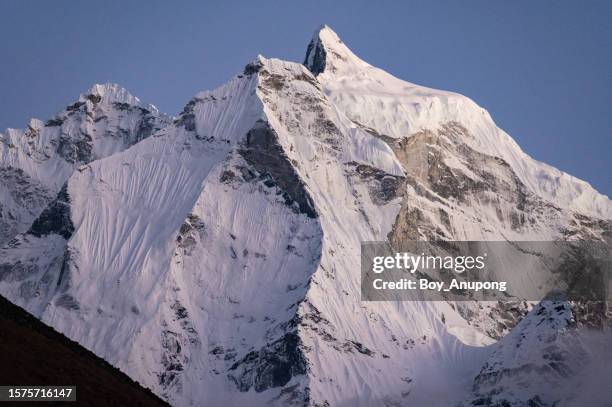 view of kangtega mountain (6779m) after sunset. this mountain known also as the snow saddle, is a major mountain peak of the himalayas in nepal. - kangtega foto e immagini stock