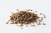 Pile of anise seeds on white surface