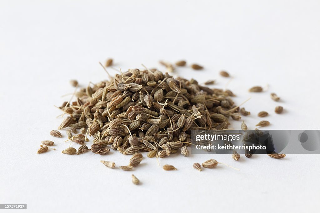 Pile of anise seeds on white surface