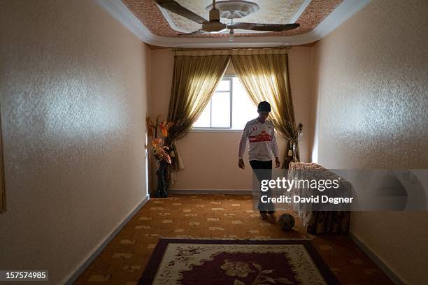 The son of Said Ibrahim Aburial plays with a soccer ball in his apartment in the Shati Refugee Camp in Gaza on November 21, 2012. During the day, it...