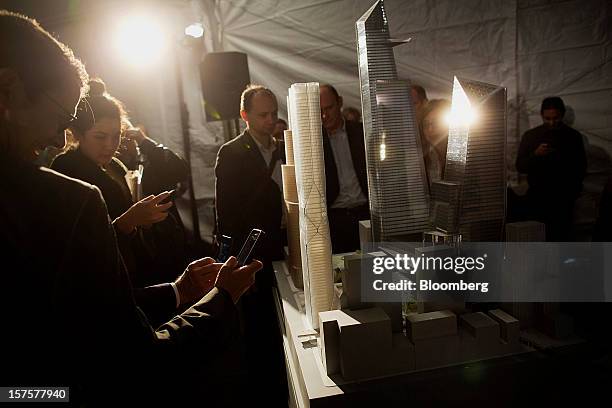 Attendees use cell phones to take photos of an architectural model of the Hudson Yards development during the groundbreaking ceremony in New York,...