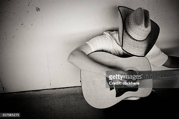 cowboy playing guitar - country and western music stock pictures, royalty-free photos & images