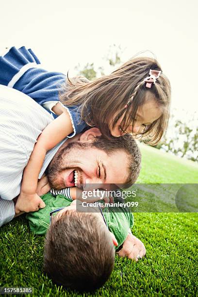 dog pile on top of daddy - play fight stock pictures, royalty-free photos & images