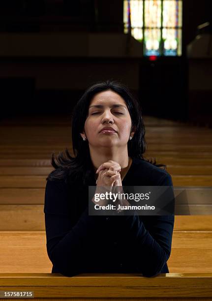 hispanic woman praying at the church - anglican prayers stock pictures, royalty-free photos & images