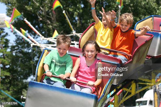 children riding on a roller coaster - fairground ride stock pictures, royalty-free photos & images