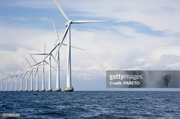 long row a very tall windmills offshore - wind stock pictures, royalty-free photos & images