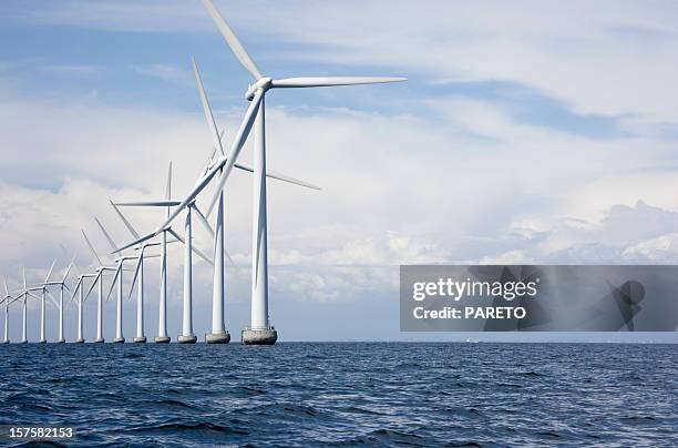 long row a very tall windmills offshore - wind turbine stock pictures, royalty-free photos & images