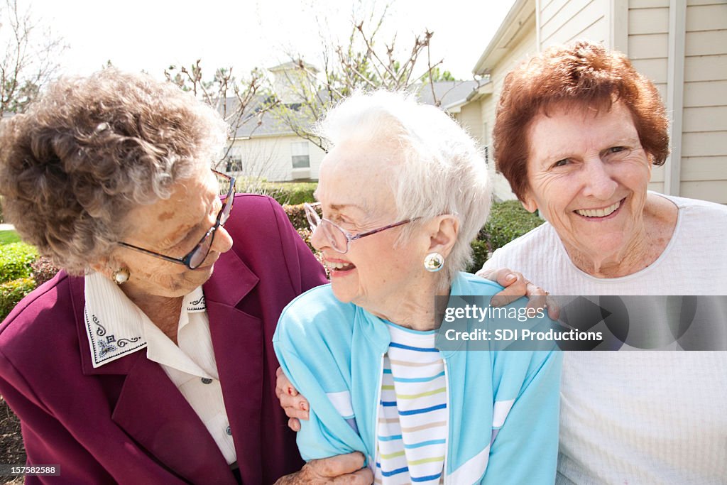 Three Senior Adult Women Laughing Together Outside in Courtyard