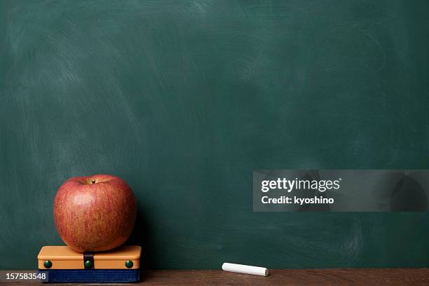 red apple with eraser and chalk in front of blackboard - gum stockfoto's en -beelden