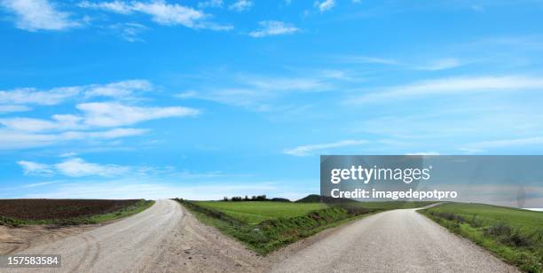 vacío calle bifurcada - crossroad fotografías e imágenes de stock