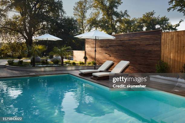 blick auf die moderne veranda mit swimmingpool. - gartenschirm stock-fotos und bilder