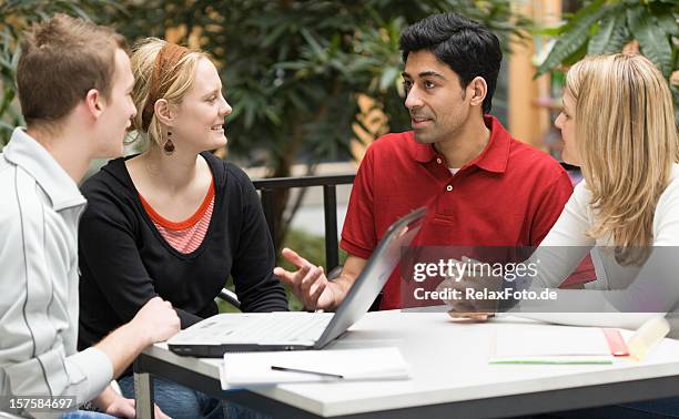 group of four multi-ethnic students in teamwork with laptop presentation - reds training session stock pictures, royalty-free photos & images