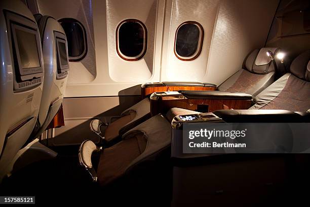 business class reclined seats of airplane - first class stock pictures, royalty-free photos & images