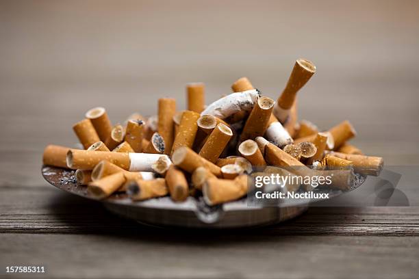 ashtray bulging with cigarettes - stubs stock pictures, royalty-free photos & images