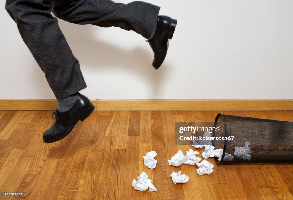 Businessman Tripping Over Wastepaper Basket