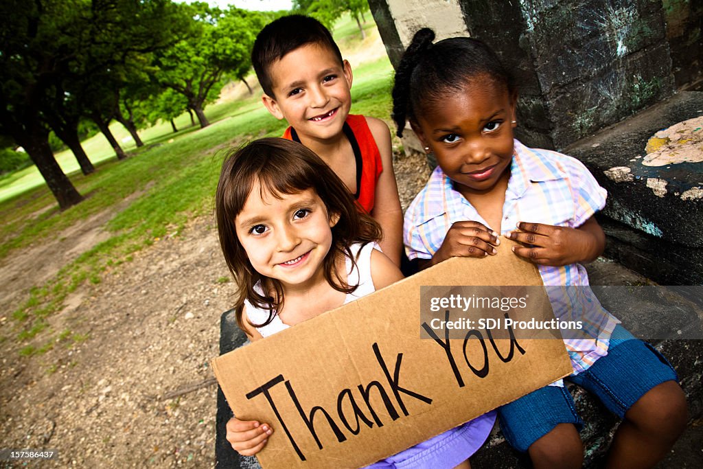 Three Cute Kids Smiling and Holding a Thank You Sign