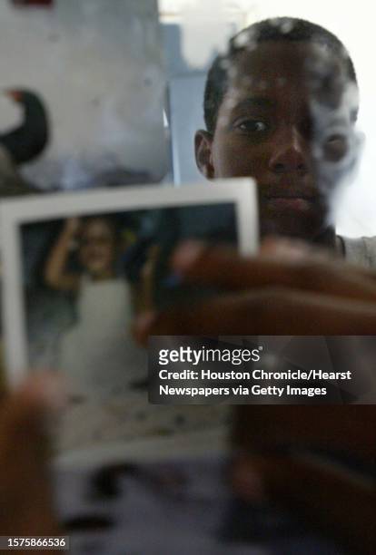 Marion Jefferson gathers photos from a vanity mirror in their bedroom as his family to packs up and evacuate from their home in the 9th Ward on...