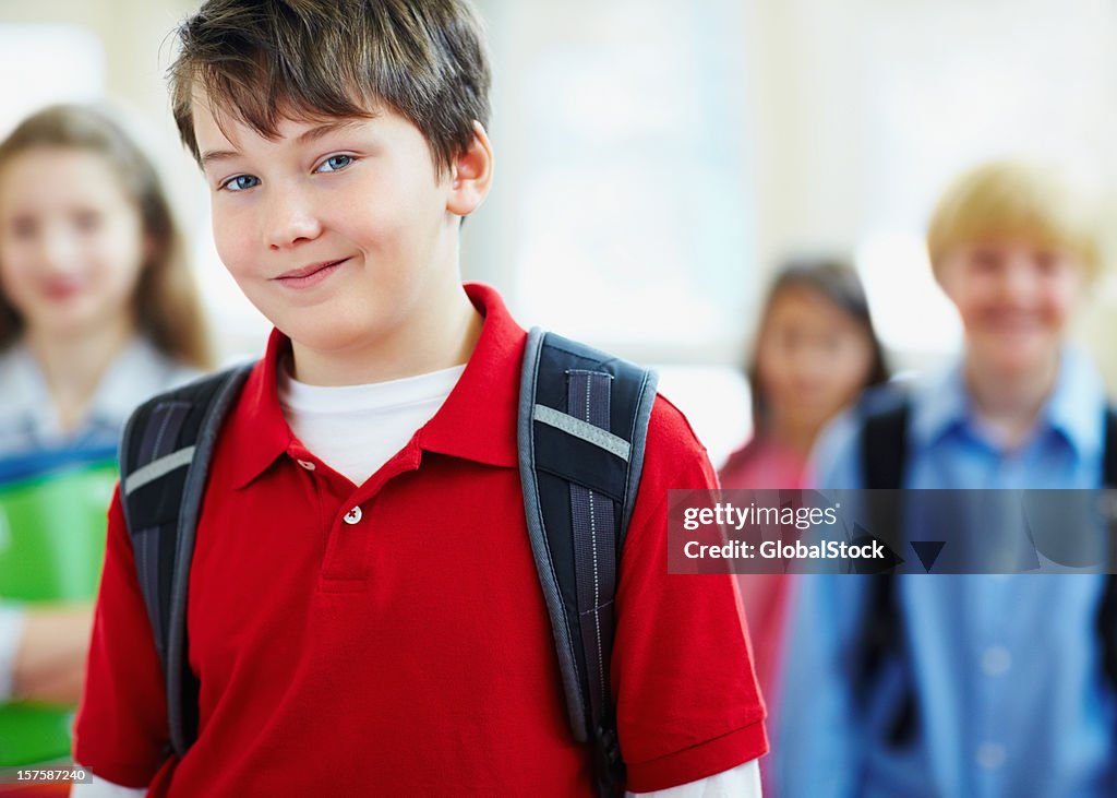 Cute little kid at school with his friends in background