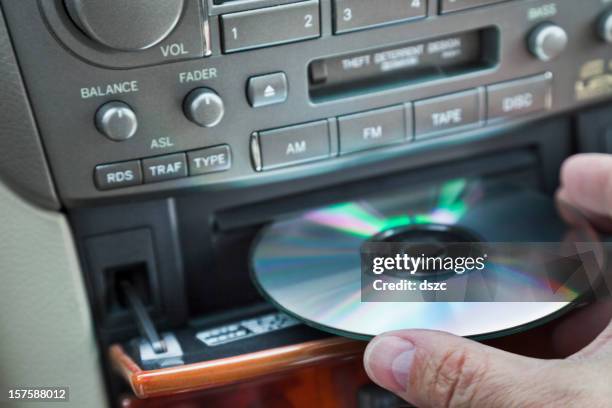 man's hand inserting cd in car player - cd player stock pictures, royalty-free photos & images
