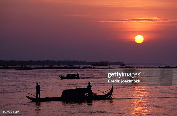 silhouetted fishermen at sunrise on the mekong river - river mekong stock pictures, royalty-free photos & images