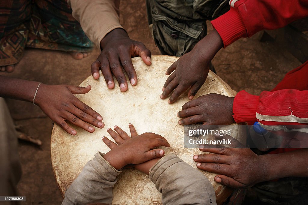 Mãos de crianças africanas tocando o grande tambor