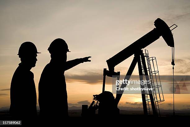 pointing at a pumpjack - petroleum geologist stock pictures, royalty-free photos & images